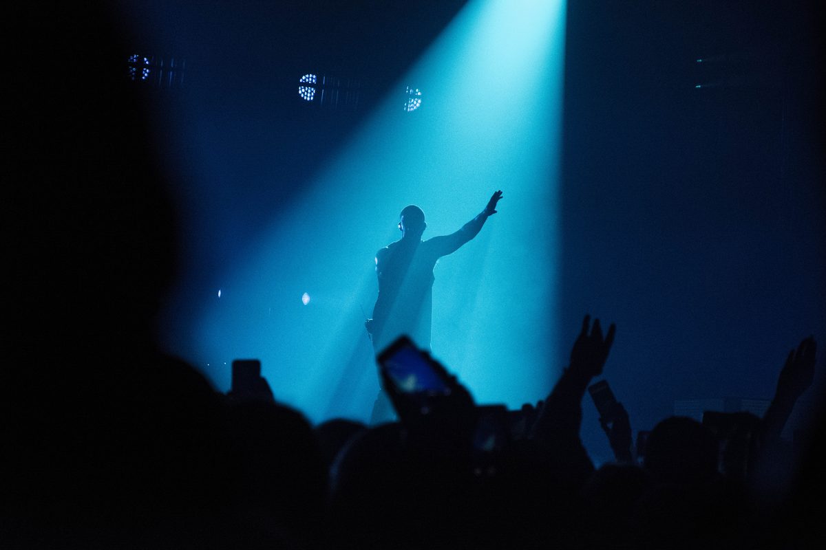 Artist på scene foran publikum under et arrangement Facefirst dekker