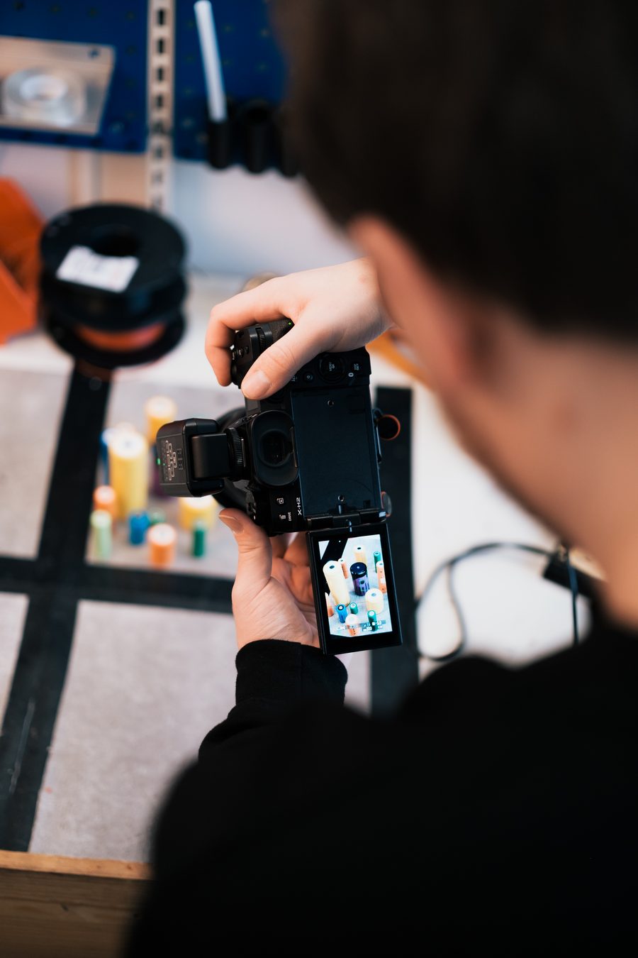 Fotograf gjennomgår produktbilder på kameraskjermen i studio