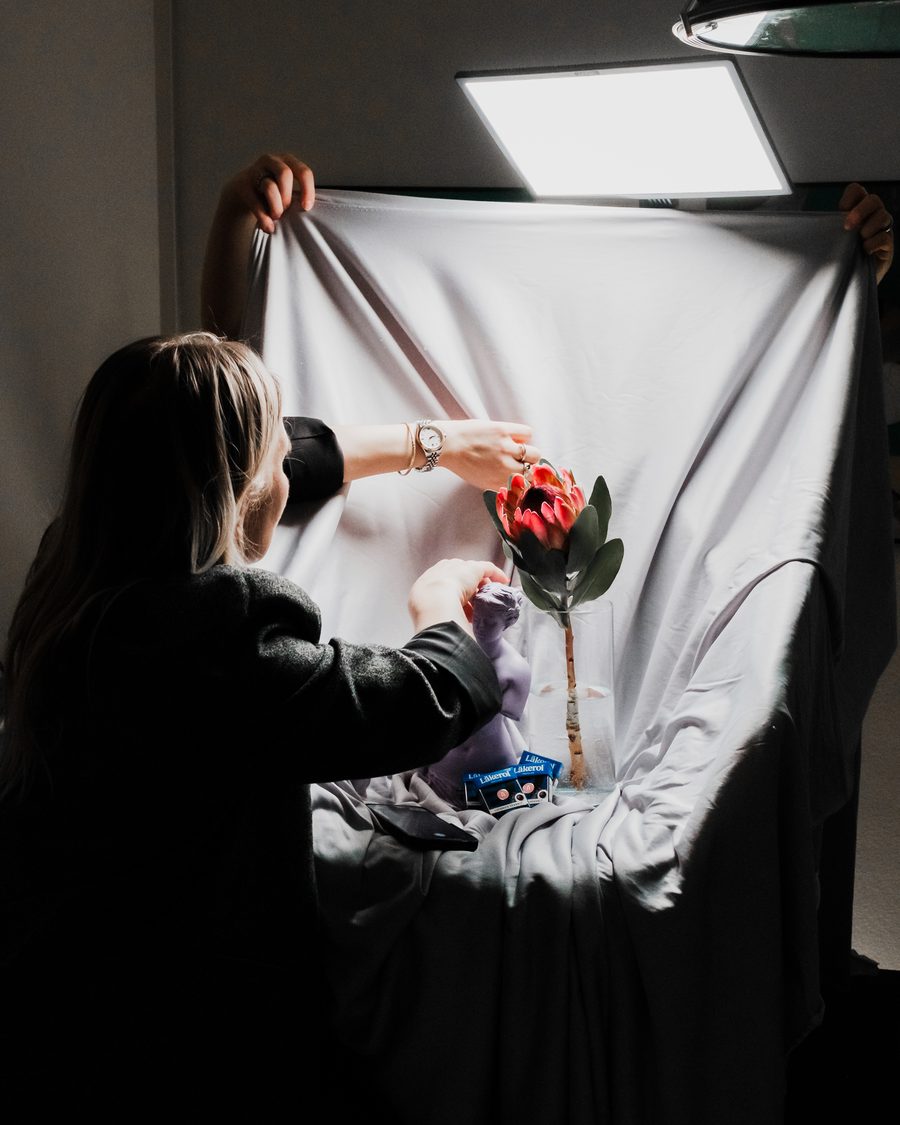 Stylist rigger lyssetting og bakgrunn i studio før en produksjon