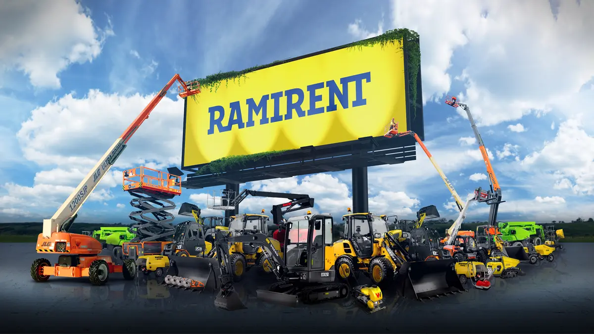 Ramirent-logo på en stor gul reklameskilttavle omgitt av løfteutstyr og anleggsmaskiner